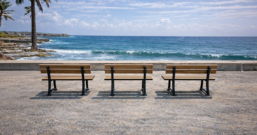 Bancs publics en bois installés face à la mer sur une promenade littorale